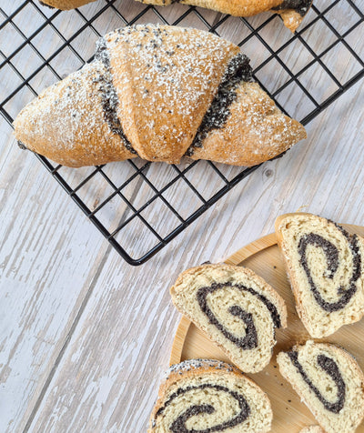 Low-Carb Poppy seed rolls on a cooling rack and wooden board with a light wood background