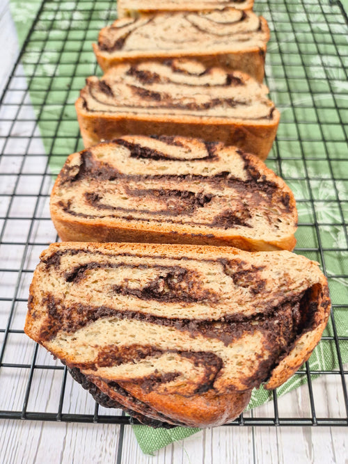 Gluten-free chocolate babka loaf sliced and arranged on a cooling rack made with ReWild CoreBake