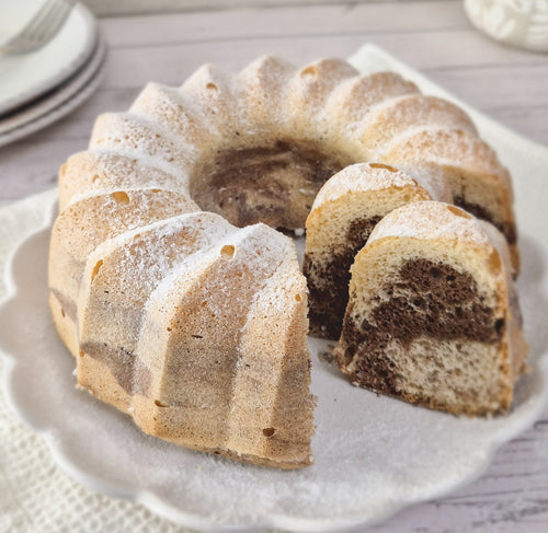 Gluten-free chocolate and vanilla marble bundt cake with a slice cut out made using ReWild CoreBake