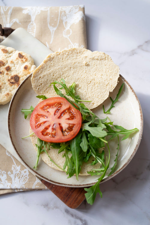 Gluten-free flatbread sandwich filled with fresh tomato and rocket made using ReWild CoreBake