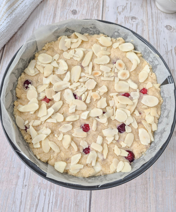 Step 8 – Topping apple cranberry cake with sliced almonds before baking